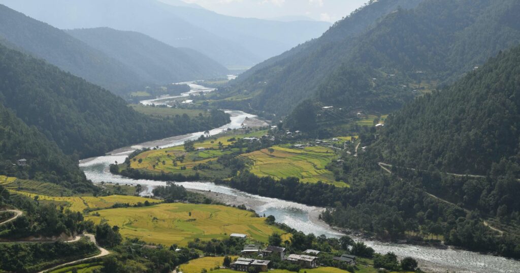 long river flowing in a valley with tiny houses