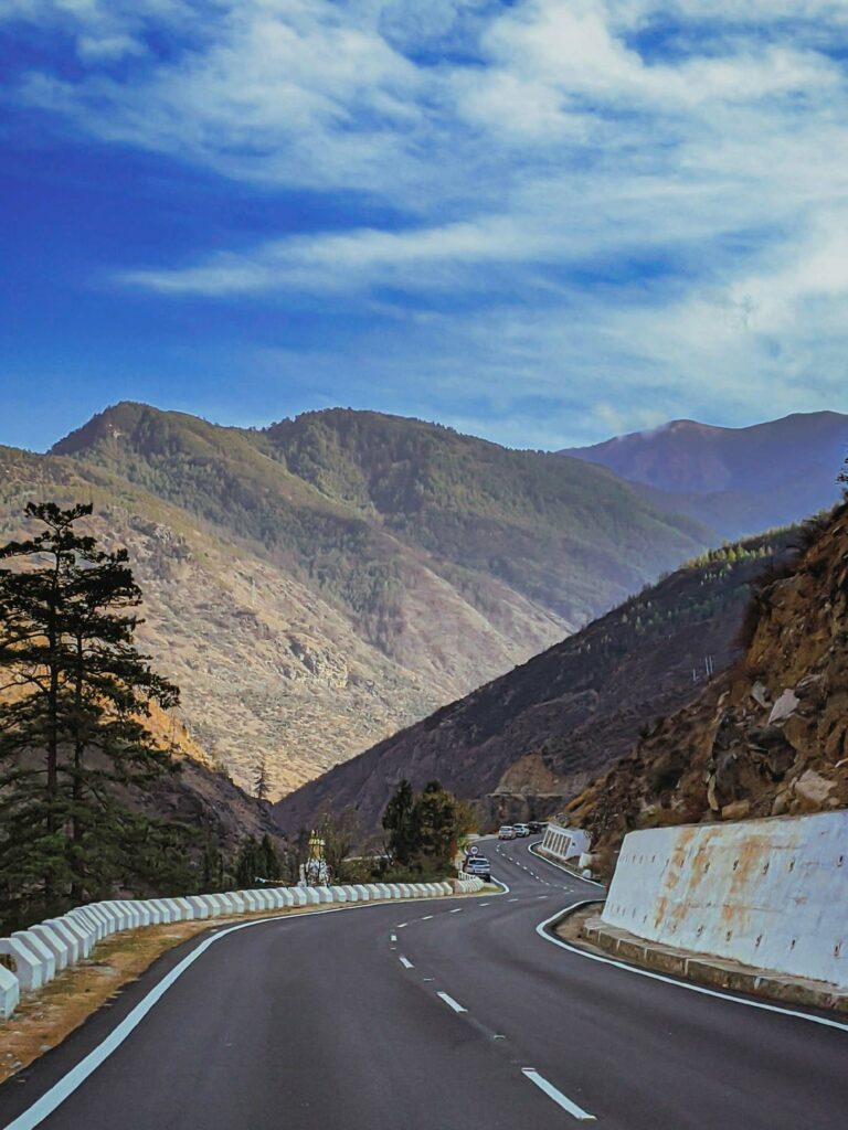 road through a mountain with views of hills under a blue sky