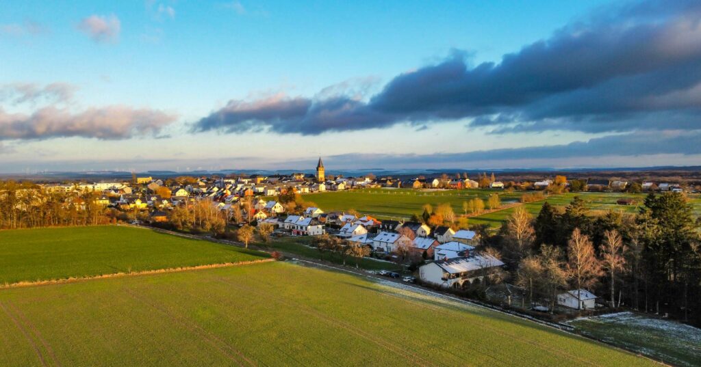 Small town with red-roofed houses clustered around a green park