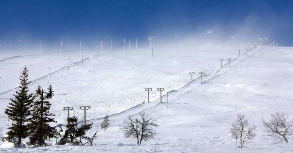 Snowy landscape with ski lifts ascending a hill